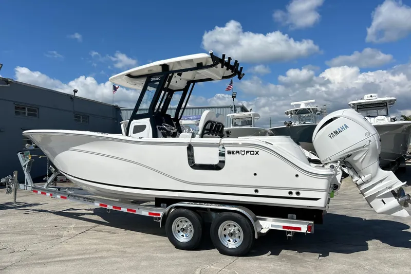 Slide: The Image of 2026 Sea Fox 268 Commander boat on trailer, featuring Yamaha engine, under clear blue sky. - 2