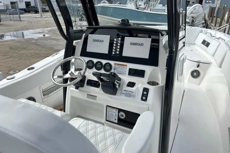 Slide: The Image of 2026 Sea Fox 268 Commander boat dashboard with Simrad displays and steering wheel. - 30