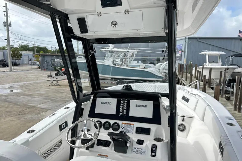 Slide: The Image of 2026 Sea Fox 268 Commander boat cockpit with Simrad navigation system, docked at a marina. - 31