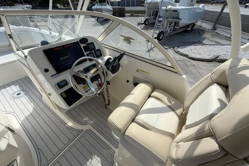 Slide: The Image of 2016 World Cat 255 DC boat cockpit with steering wheel and Garmin navigation system. - 10