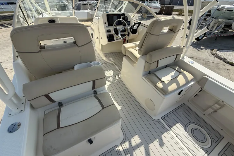 Slide: The Image of 2016 World Cat 255 DC boat interior with beige seating and steering console. - 15