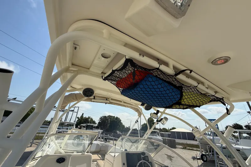 Slide: The Image of 2016 World Cat 255 DC boat interior with overhead storage net and colorful gear. - 16