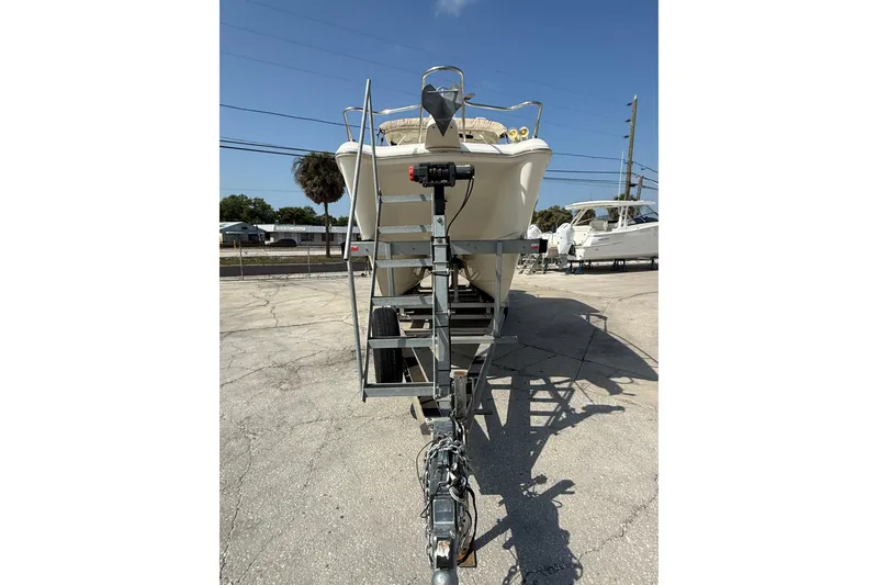 Slide: The Image of 2016 World Cat 255 DC boat on trailer, parked outdoors under clear sky. - 3