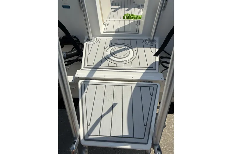 Slide: The Image of 2016 World Cat 255 DC boat deck with textured flooring and metal railings. - 8