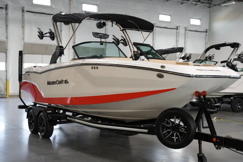 Slide: The Image of 2025 MasterCraft NXT24 boat on trailer in indoor showroom. - 5