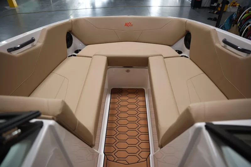 Slide: The Image of 2025 MasterCraft NXT24 boat interior with beige seating and hexagonal floor design. - 8