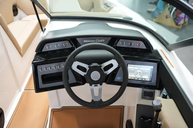 Slide: The Image of 2025 MasterCraft NXT24 boat dashboard with steering wheel and touchscreen controls. - 9