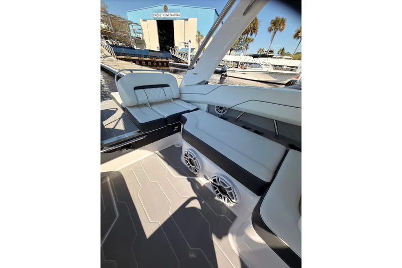 Slide: The Image of 2019 Regal LS4 boat interior with white seating and speakers at a marina. - 15