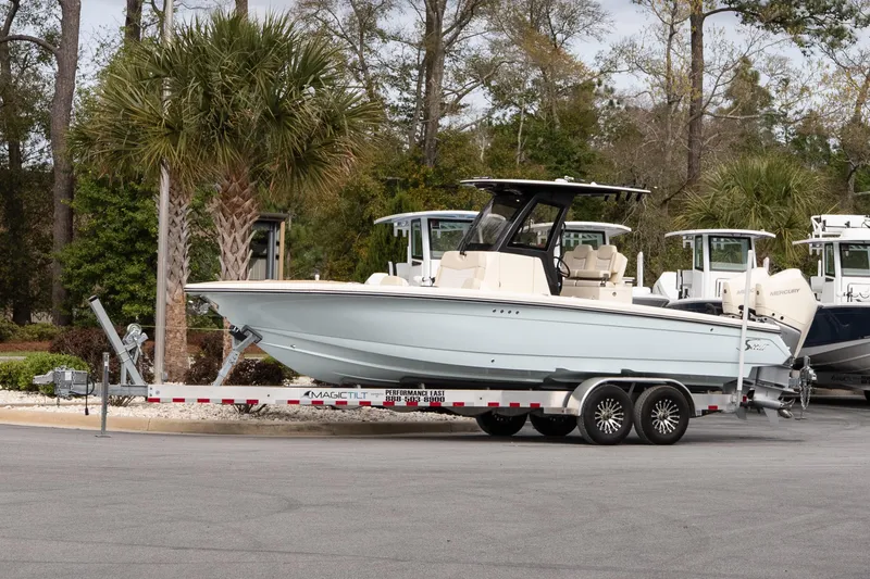 Slide: The Image of 2026 Scout 281 XSS boat on trailer, parked near palm trees. - 1