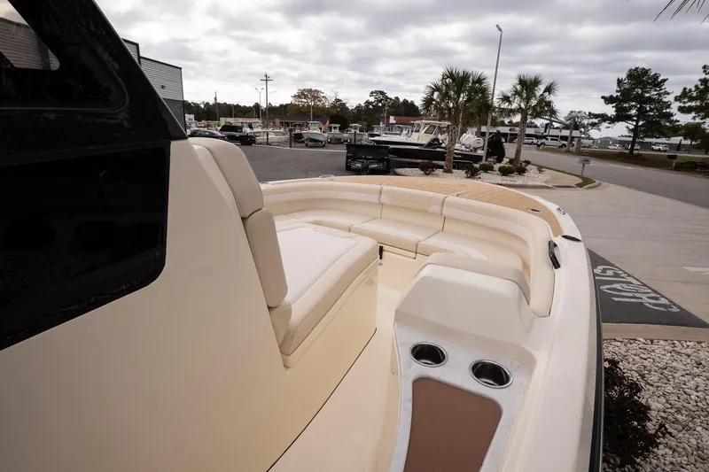 Slide: The Image of 2026 Scout 281 XSS boat with spacious seating, docked near palm trees. - 13
