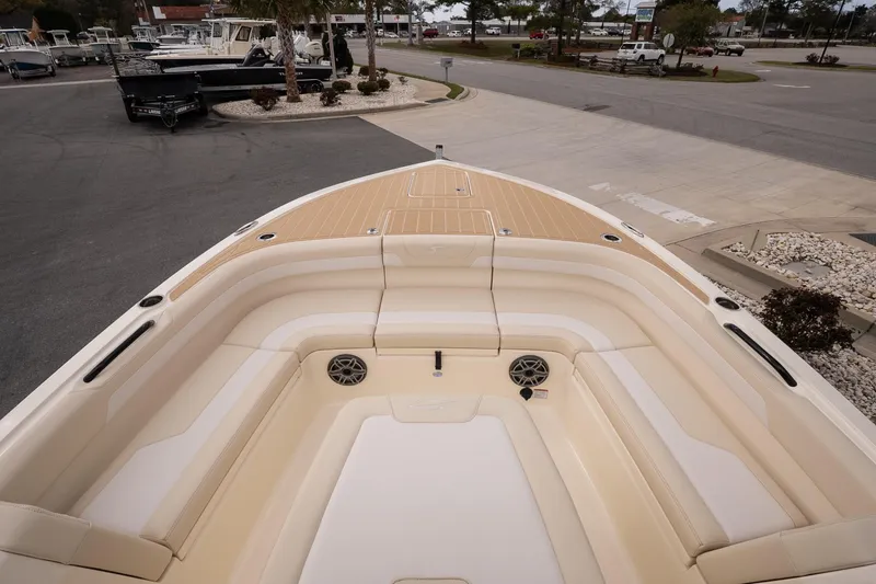 Slide: The Image of 2026 Scout 281 XSS boat interior with beige seating and deck, parked outdoors. - 15