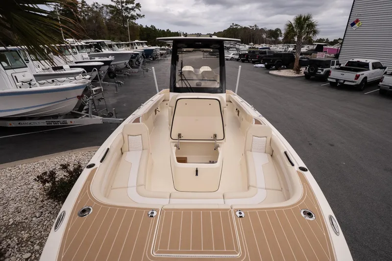 Slide: The Image of 2026 Scout 281 XSS boat with spacious deck and seating, displayed at a marina. - 18