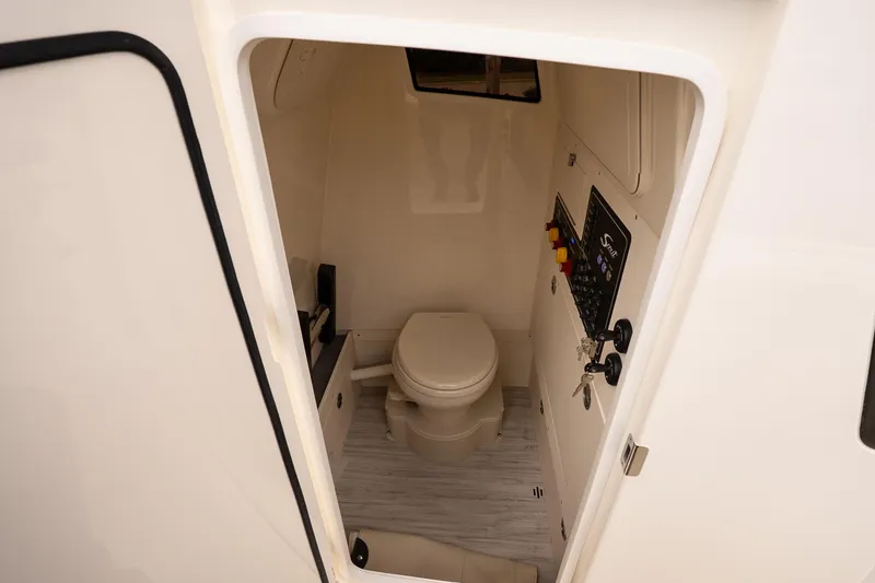 Slide: The Image of 2026 Scout 281 XSS boat interior with compact marine toilet and control panel. - 22