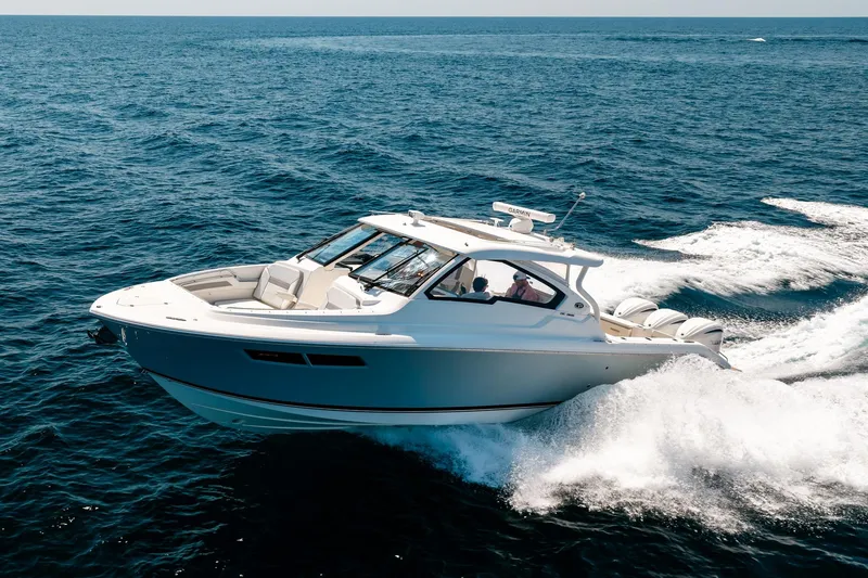 The Image of 2022 Pursuit DC 365 Dual Console boat cruising on open ocean waters. - 0