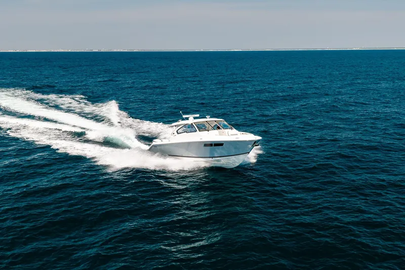 Slide: The Image of 2022 Pursuit DC 365 Dual Console cruising on open ocean waters. - 10