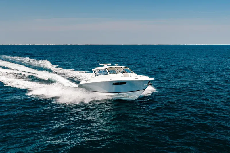 Slide: The Image of 2022 Pursuit DC 365 Dual Console cruising on open blue ocean. - 11