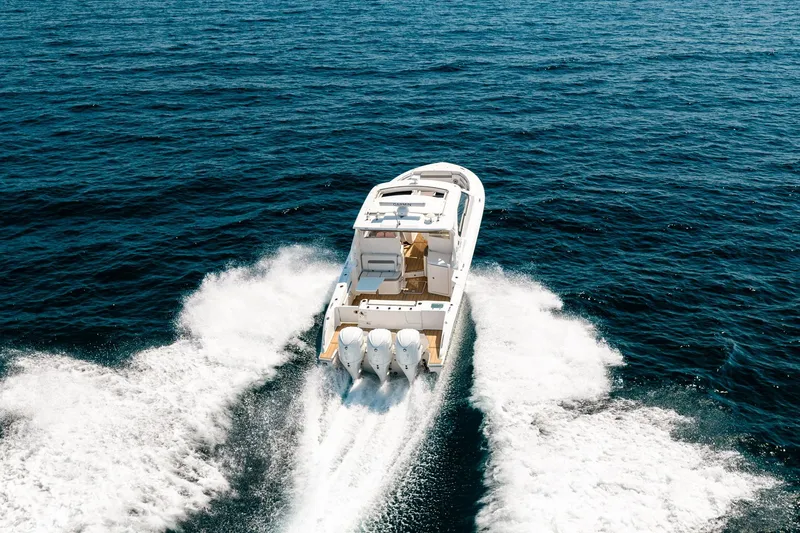 Slide: The Image of 2022 Pursuit DC 365 Dual Console cruising on open ocean waters. - 13