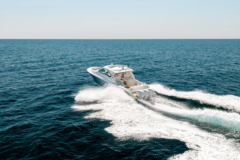 Slide: The Image of 2022 Pursuit DC 365 Dual Console cruising on open ocean waters. - 14