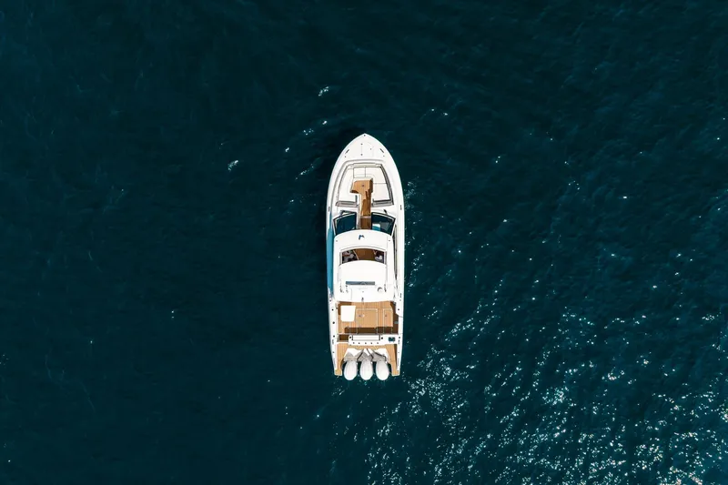 Slide: The Image of Aerial view of 2022 Pursuit DC 365 Dual Console boat on open water. - 2