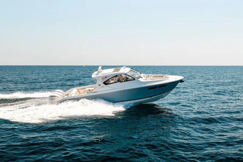 Slide: The Image of 2022 Pursuit DC 365 Dual Console boat cruising on open sea. - 20