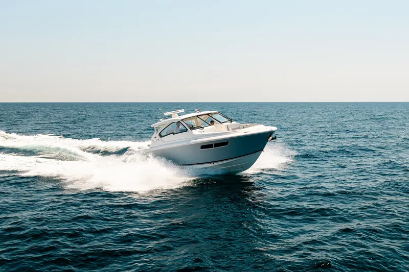 Slide: The Image of 2022 Pursuit DC 365 Dual Console boat cruising on open sea under clear sky. - 21