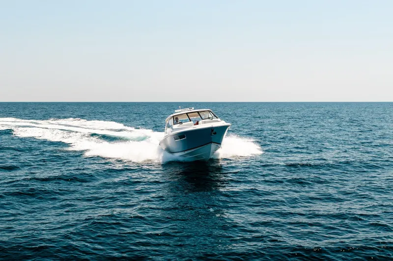 Slide: The Image of 2022 Pursuit DC 365 Dual Console cruising on open ocean waters. - 22