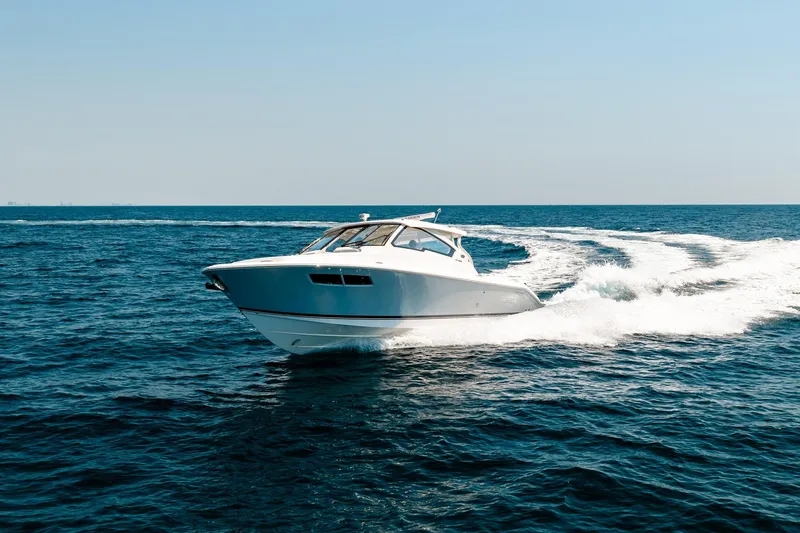 Slide: The Image of 2022 Pursuit DC 365 Dual Console cruising on open ocean waters. - 23