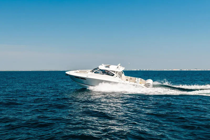 Slide: The Image of 2022 Pursuit DC 365 Dual Console boat cruising on open blue ocean. - 33