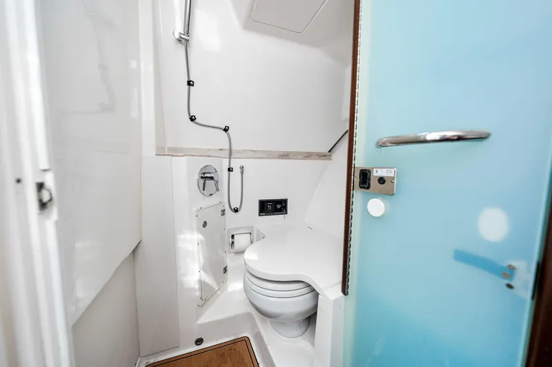 Slide: The Image of 2022 Pursuit DC 365 Dual Console boat bathroom interior with modern fixtures and blue door. - 35