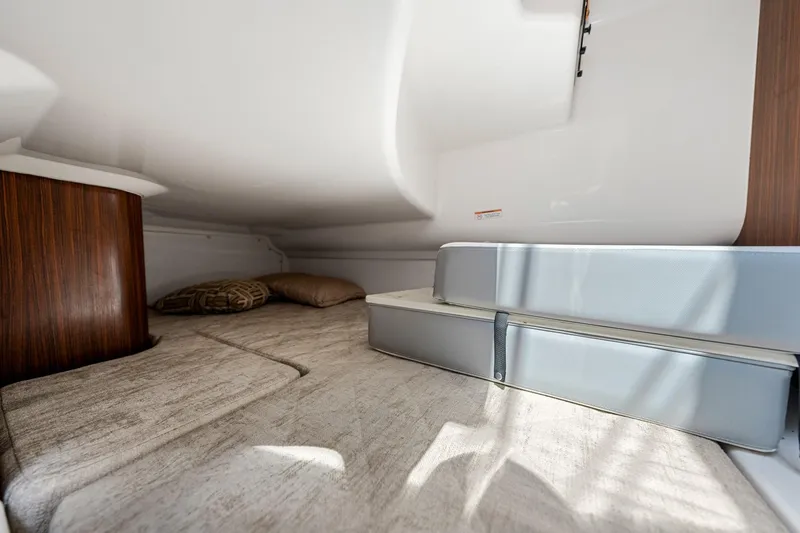 Slide: The Image of Interior cabin of 2022 Pursuit DC 365 Dual Console boat, featuring cozy bedding and cushions. - 39