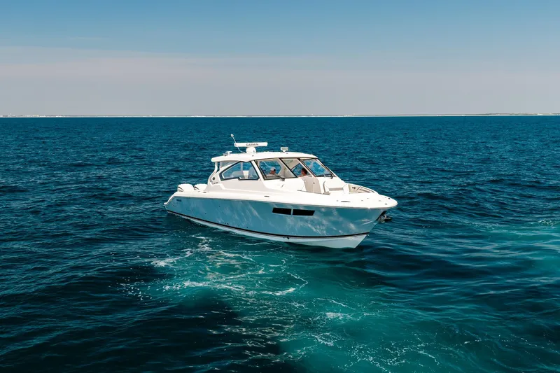 Slide: The Image of 2022 Pursuit DC 365 Dual Console boat cruising on open blue ocean. - 4