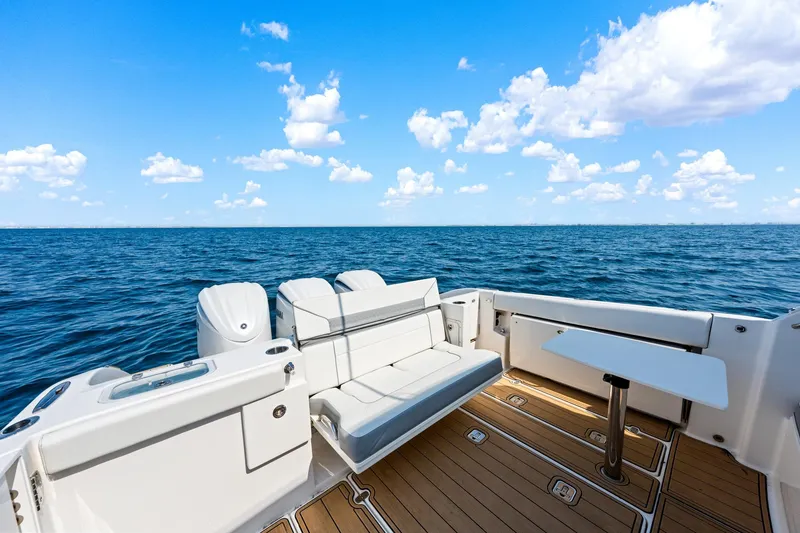 Slide: The Image of 2022 Pursuit DC 365 Dual Console boat with seating and table on open water. - 42