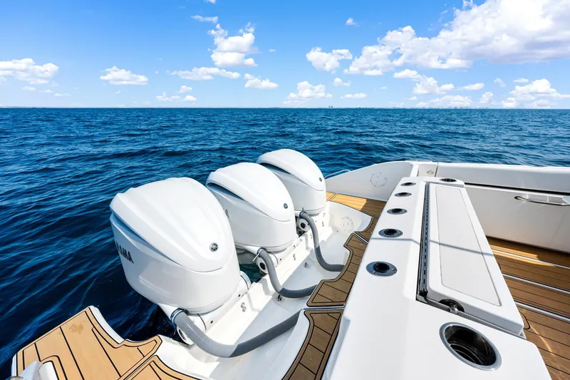 Slide: The Image of 2022 Pursuit DC 365 Dual Console boat with triple outboard engines on open sea. - 47