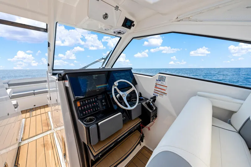 Slide: The Image of 2022 Pursuit DC 365 Dual Console boat interior with ocean view and modern dashboard. - 55