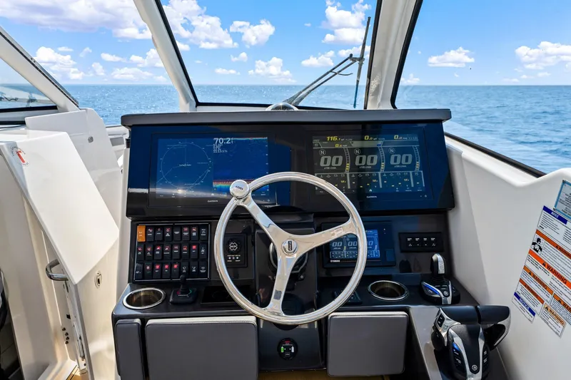 Slide: The Image of 2022 Pursuit DC 365 Dual Console helm with modern navigation displays and ocean view. - 56