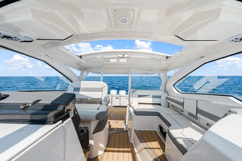 Slide: The Image of 2022 Pursuit DC 365 Dual Console boat interior with ocean view, featuring luxurious seating. - 66