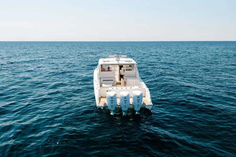 Slide: The Image of 2022 Pursuit DC 365 Dual Console boat on open sea, rear view. - 7