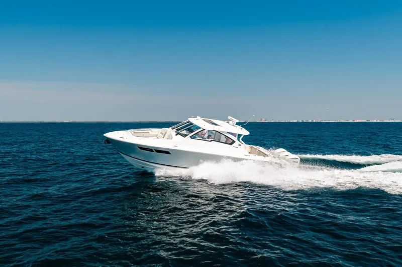 Slide: The Image of 2022 Pursuit DC 365 Dual Console boat cruising on open blue ocean. - 73