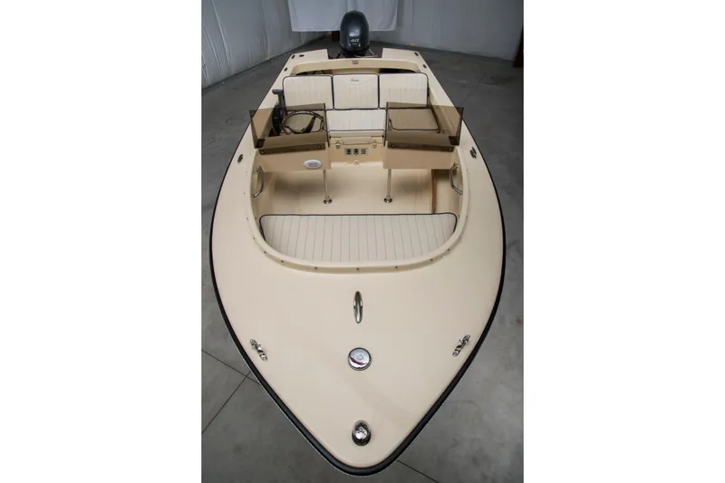 Slide: The Image of 2026 Rossiter 14 boat interior with seating and steering console in a showroom. - 2