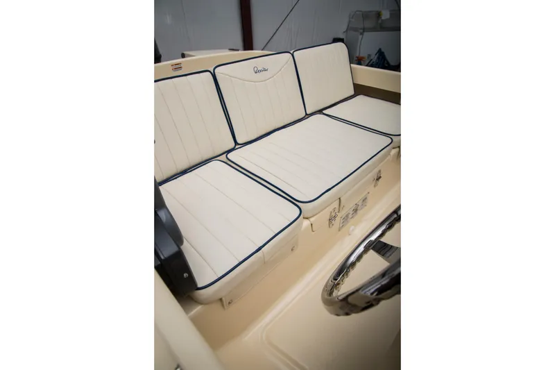 Slide: The Image of 2026 Rossiter 14 boat interior with cream cushioned seating and blue trim. - 6