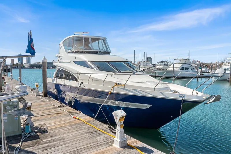 Slide: The Image of 2007 Marquis 55 LS yacht docked at marina under clear blue sky. - 2