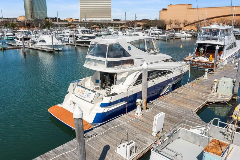 Slide: The Image of 2007 Marquis 55 LS yacht docked at a marina, surrounded by other boats. - 4