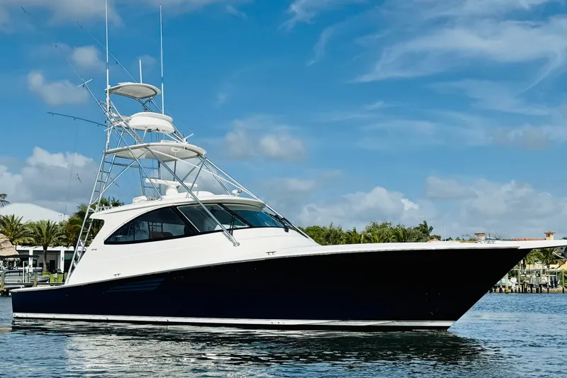 The Image of 2017 Viking 52 Sport Tower yacht on calm water under blue sky. - 0