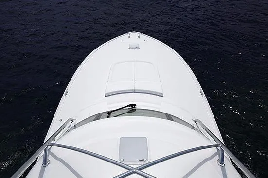 Slide: The Image of 2017 Viking 52 Sport Tower yacht on calm water, with a clear sky backdrop. - 11