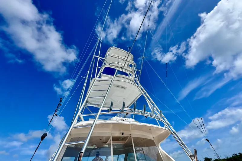 Slide: The Image of 2017 Viking 52 Sport Tower yacht against a vibrant blue sky with clouds. - 19