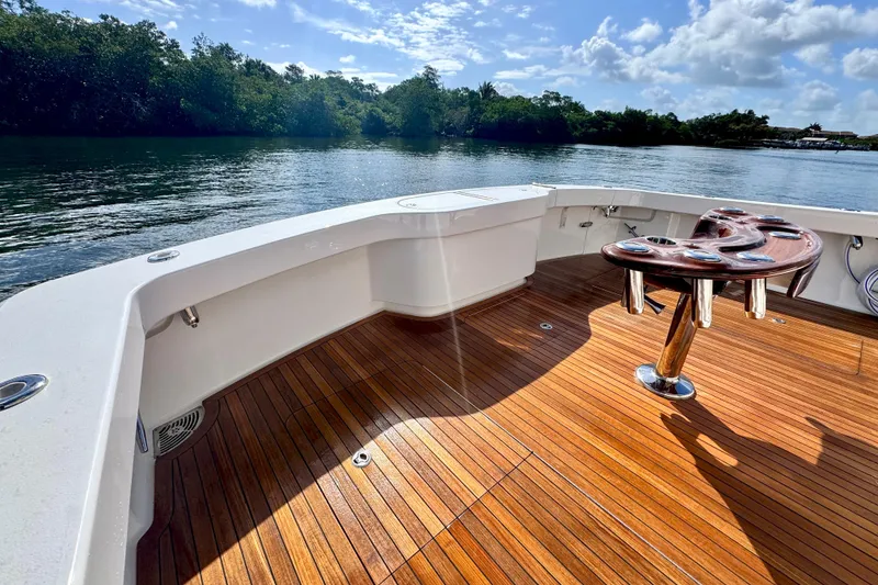 Slide: The Image of 2017 Viking 52 Sport Tower boat deck with wooden flooring and scenic water view. - 23