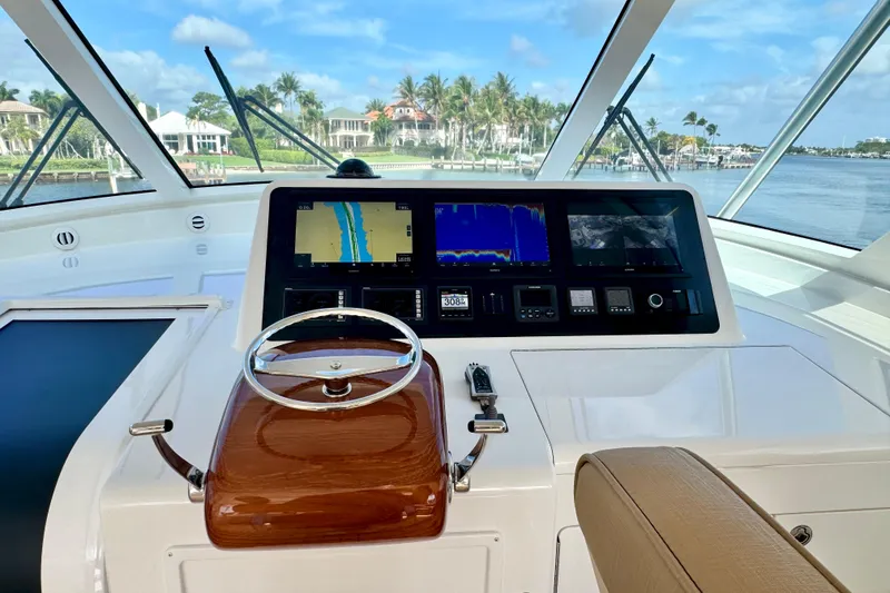 Slide: The Image of Cockpit view of 2017 Viking 52 Sport Tower with navigation screens and steering wheel. - 43