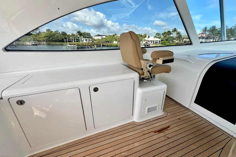 Slide: The Image of Interior of 2017 Viking 52 Sport Tower yacht with a captain's chair and scenic window view. - 45