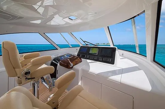 Slide: The Image of 2017 Viking 52 Sport Tower yacht on water, clear sky, palm trees in background. - 5