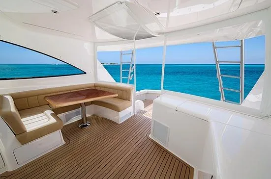 Slide: The Image of 2017 Viking 52 Sport Tower yacht on water, clear sky, palm trees in background. - 6